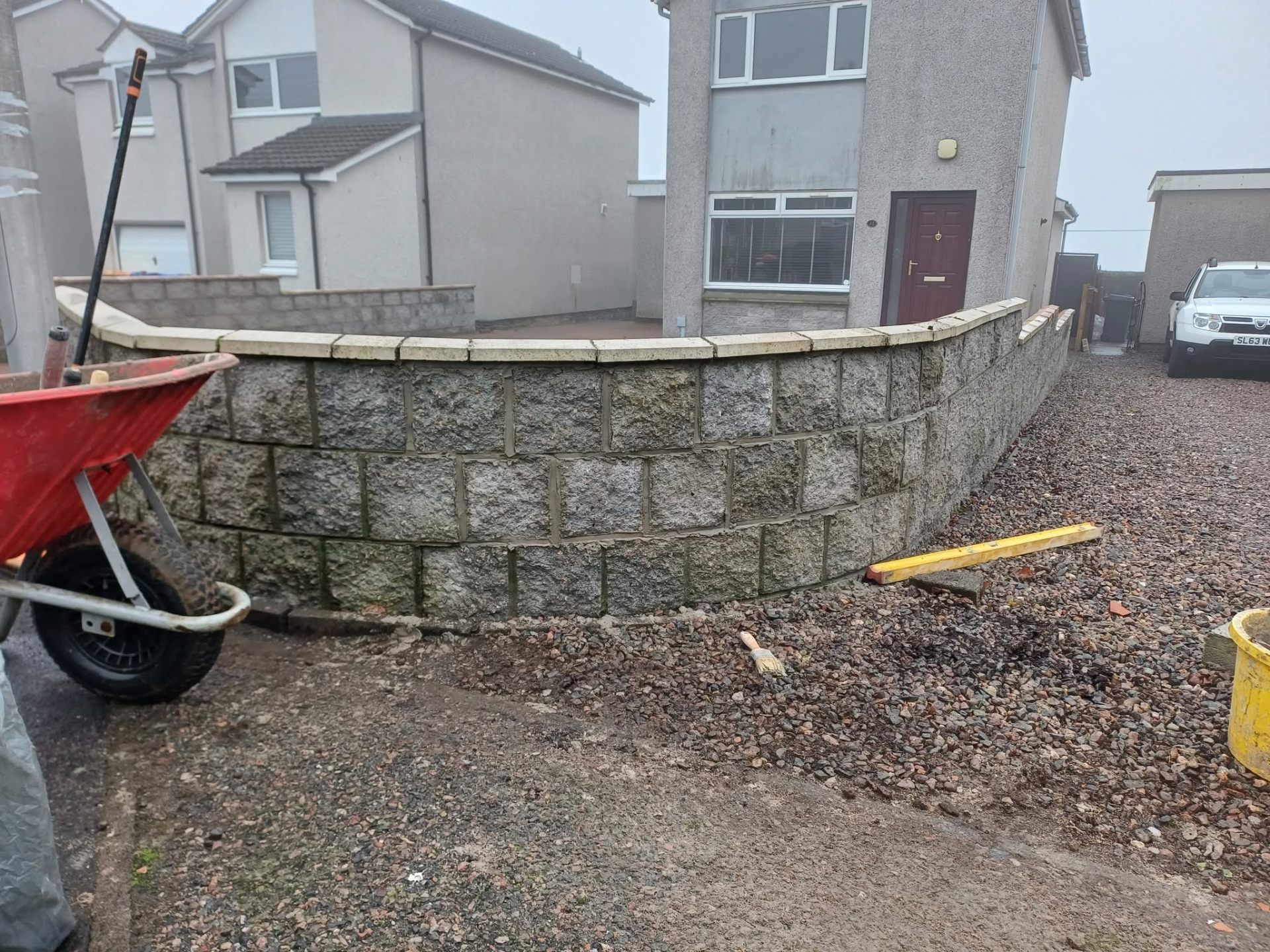 Curved granite block garden wall with coping stones