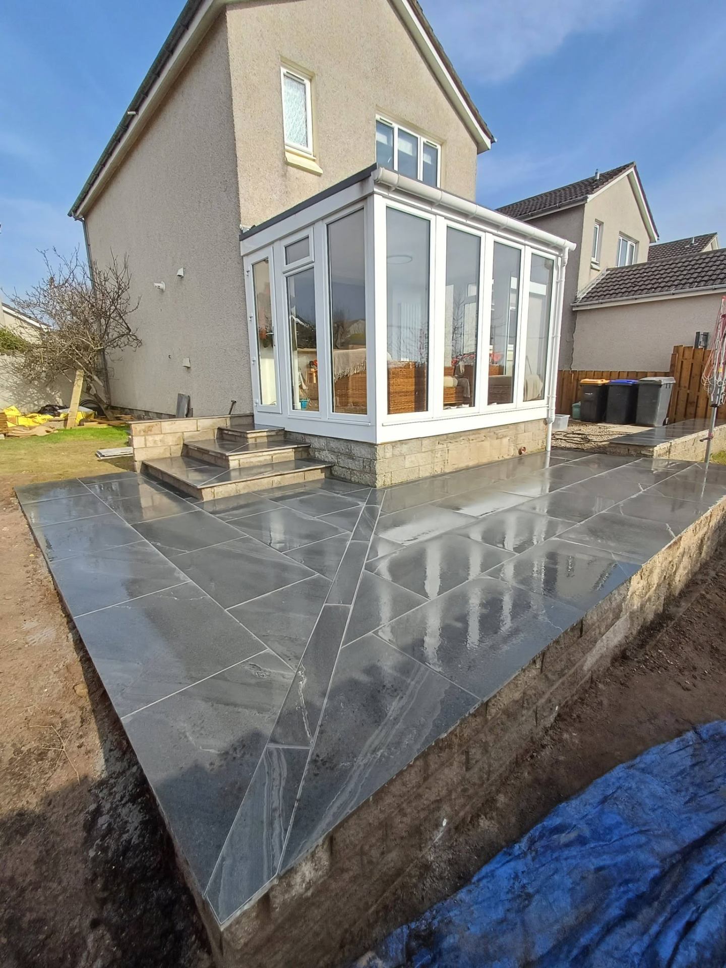Black slate patio laid around a conservatory extension